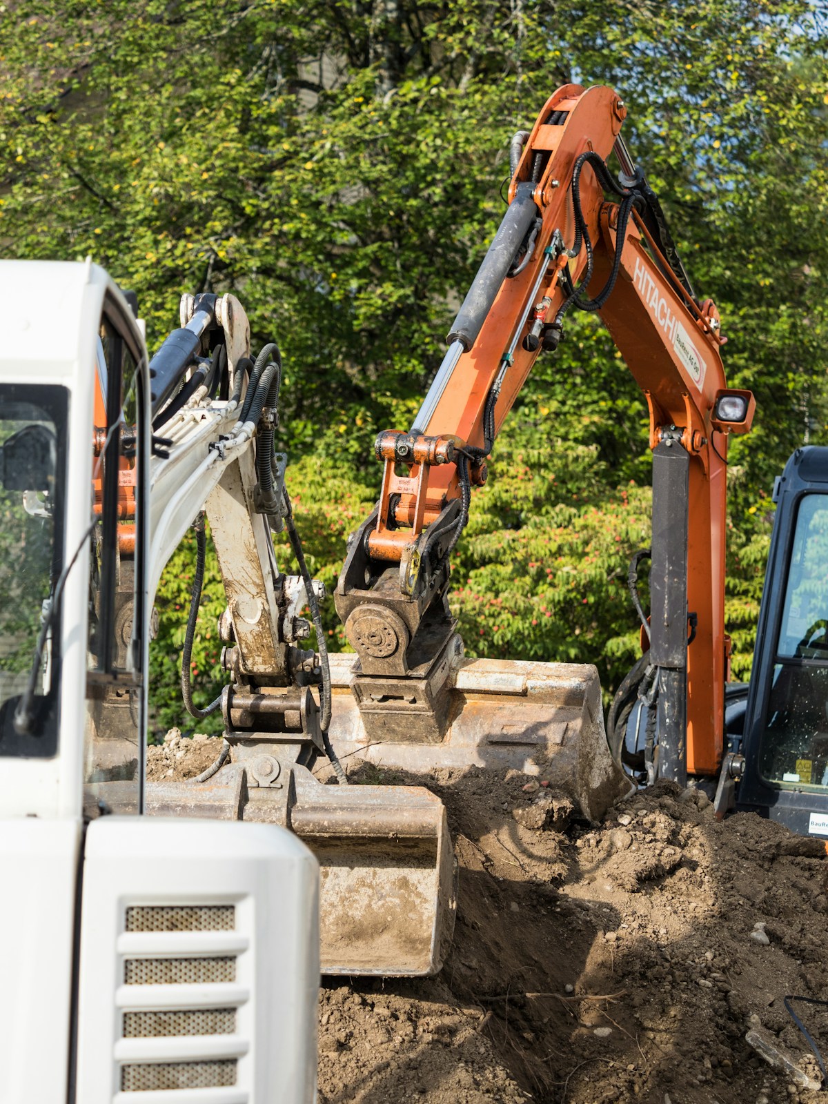 Bagger beim Aushub der Baugrube für einen Naturpool im Garten